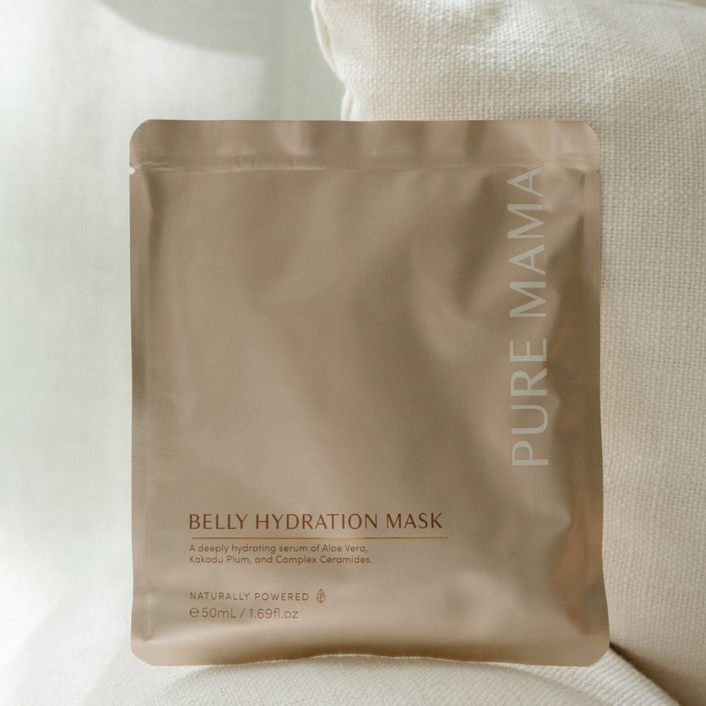 A beige Pure Mama NZ packet stands against a light fabric background. The Belly Hydration Mask is a hydrating sheet mask with aloe vera, kakadu plum, and ceramides to support the skin barrier and care for stretch marks.